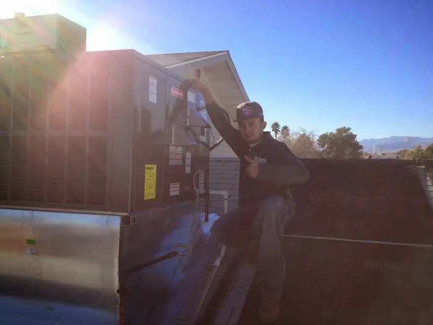 HVAC technician performing Heat Pump Repair on a rooftop unit in Edgewood